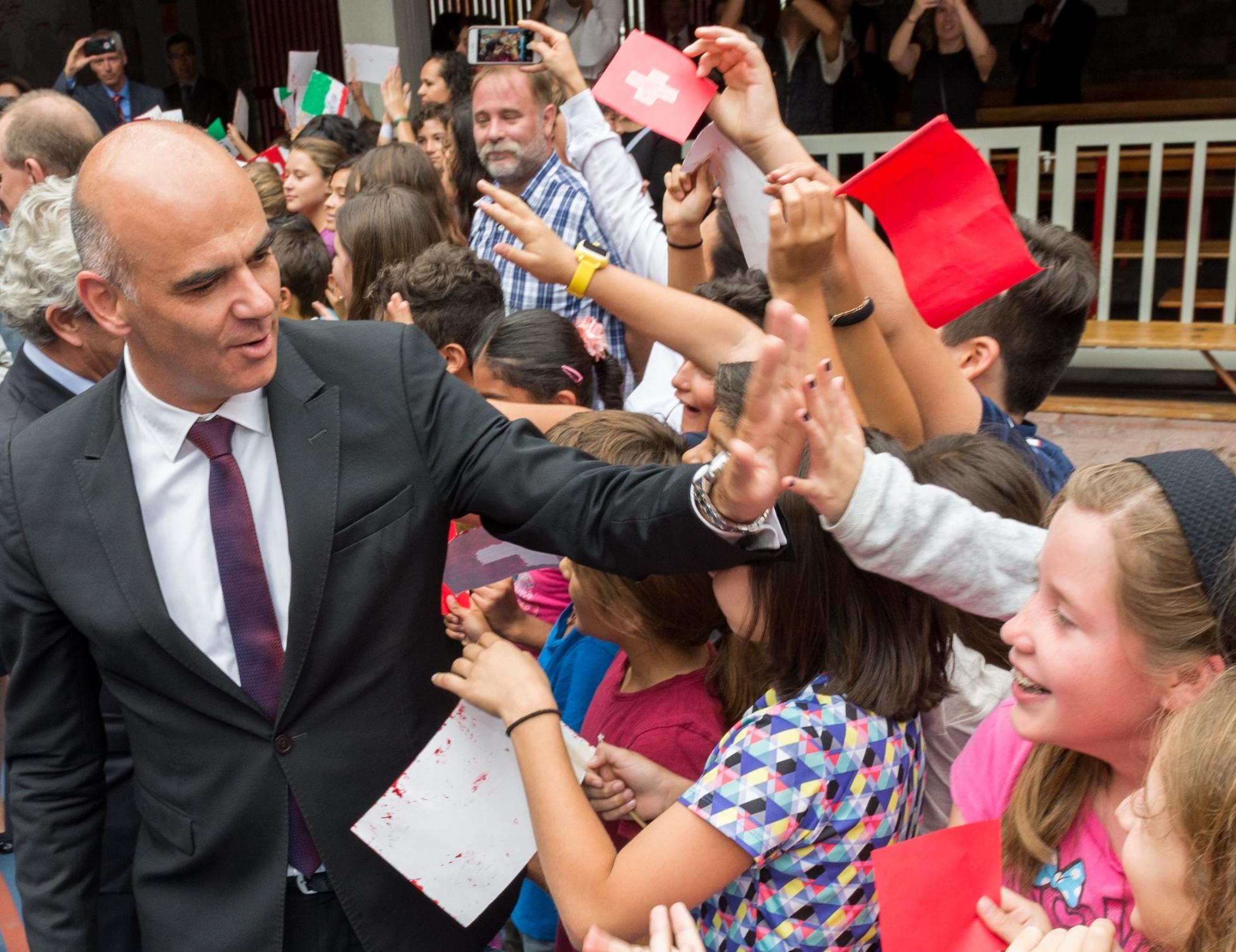 Bundesrat Alain Berset klatscht Kinder ab