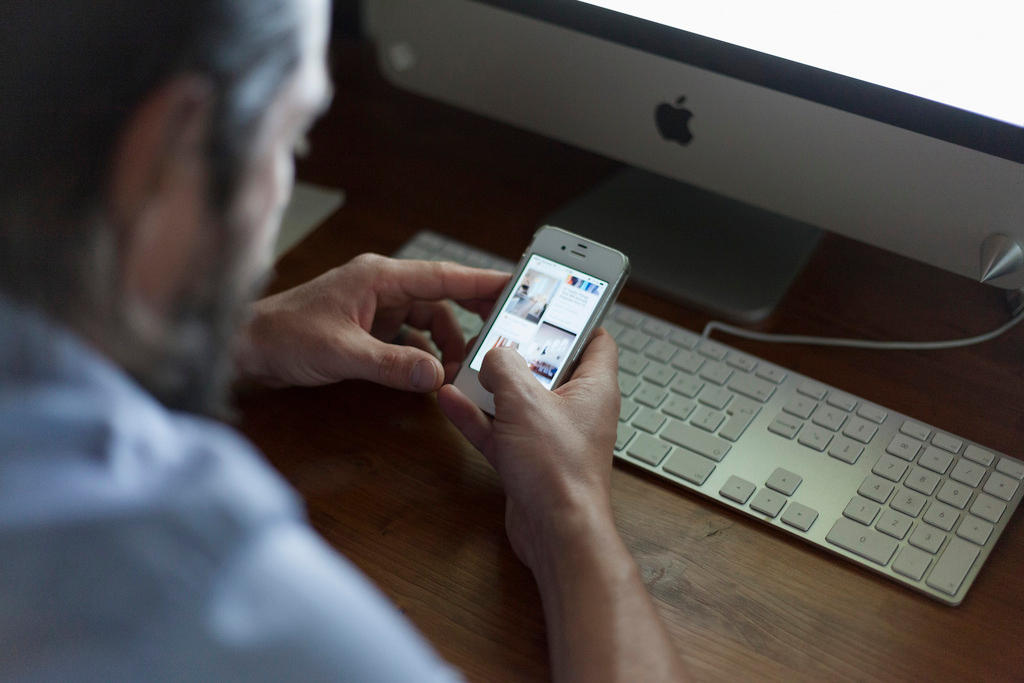 Homem manuseando um smart-phone