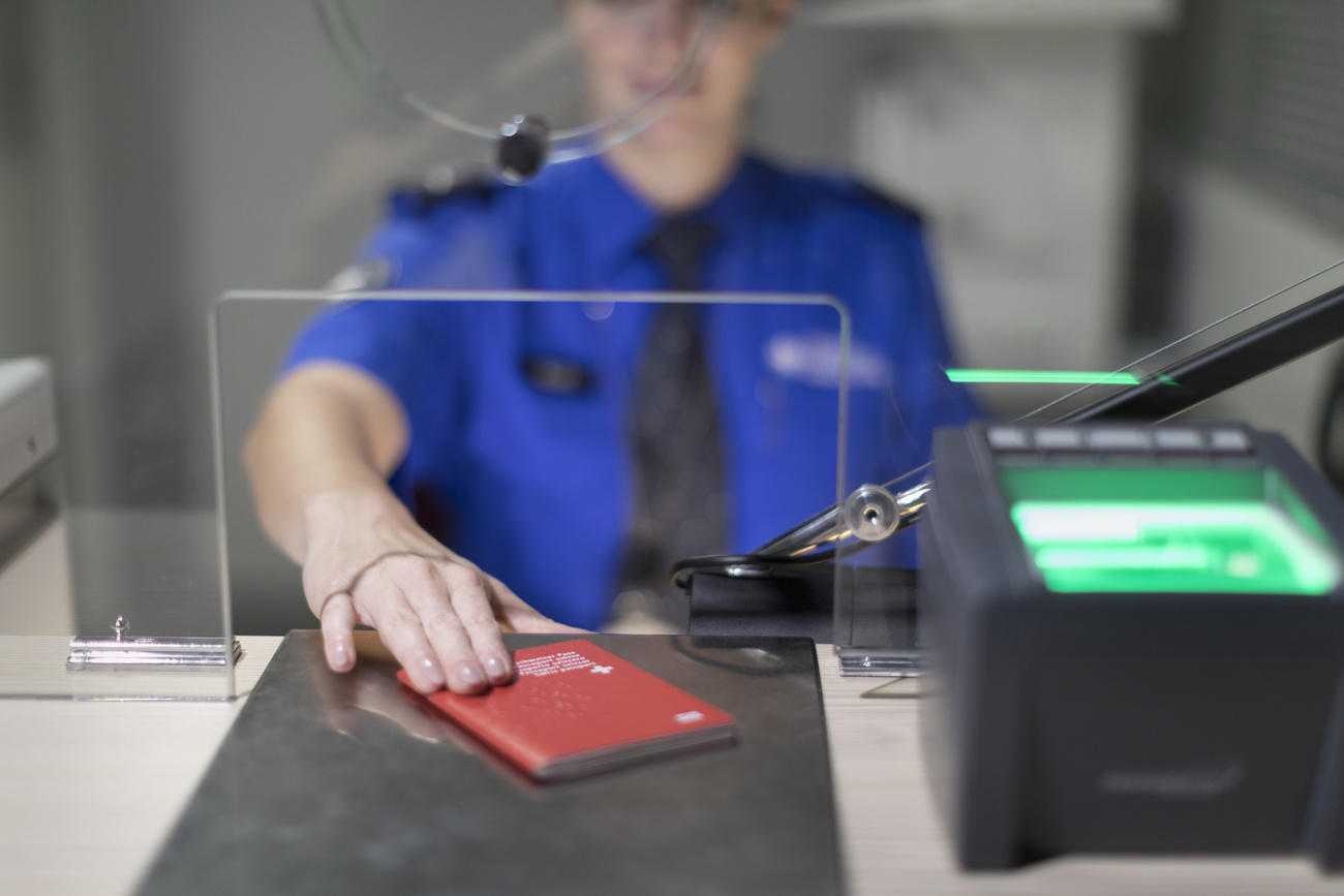 Zollbeamter schiebt Schweizer Pass am Schalter zurück