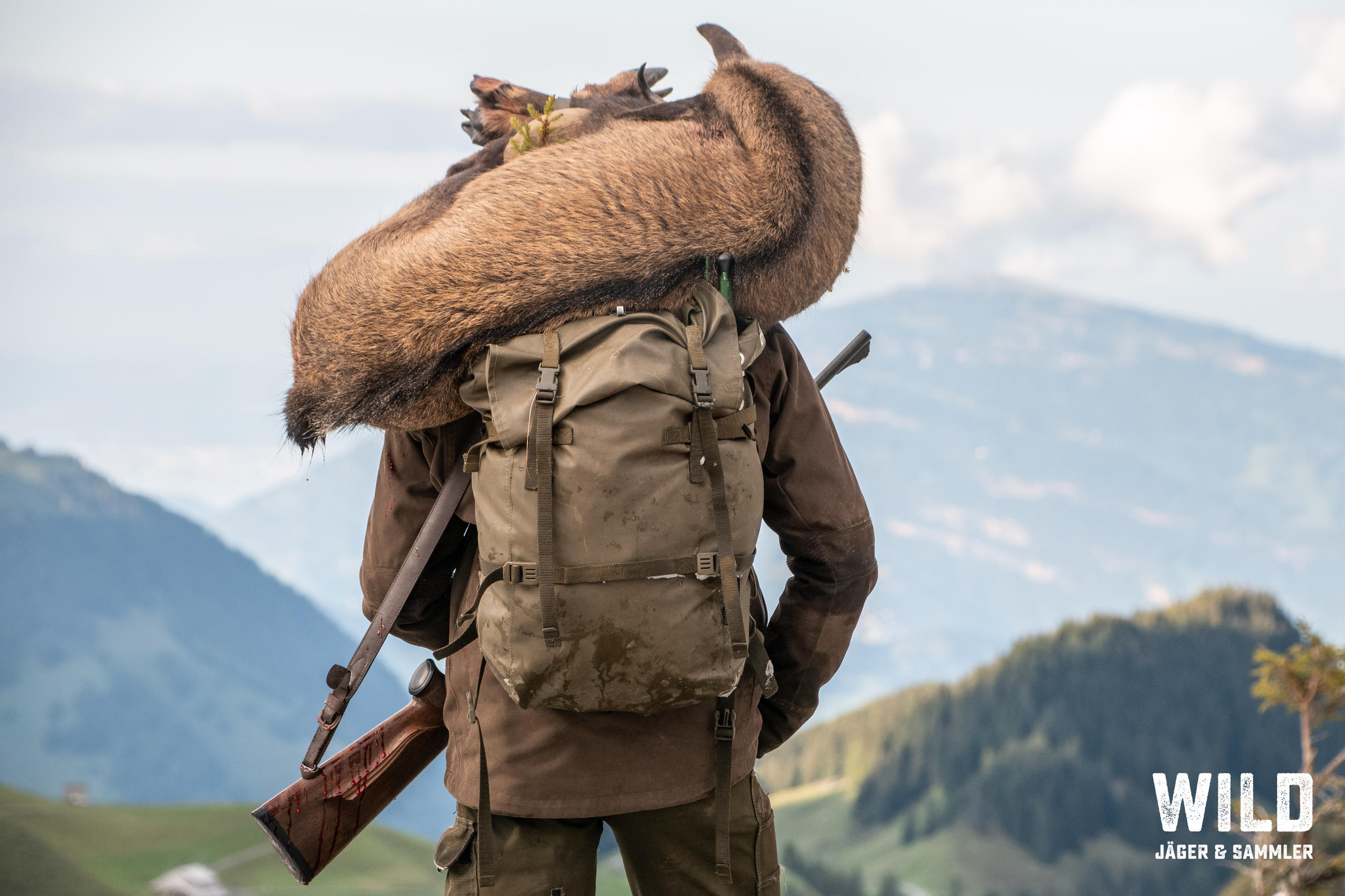 Ein Jäger mit einem Reh auf seinen Schultern