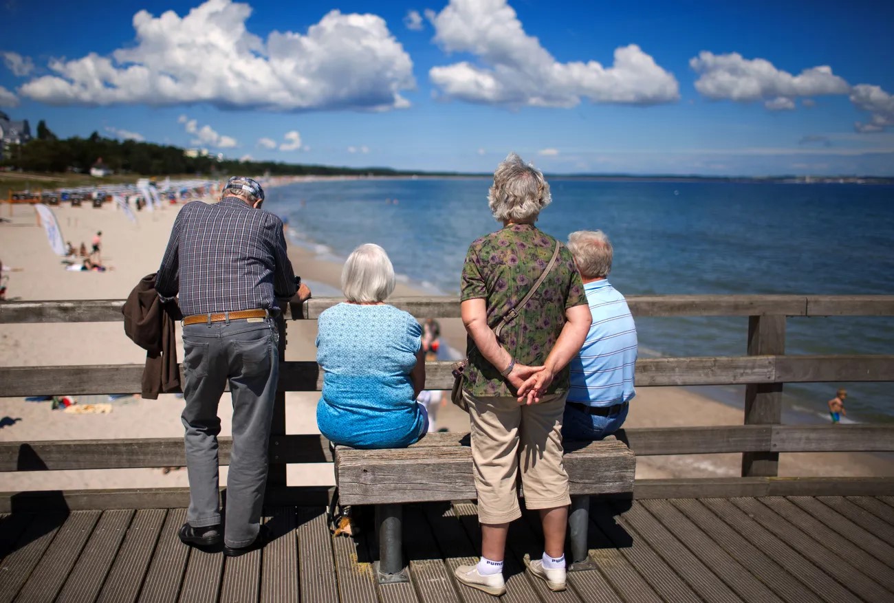 Persone anziane di spalle in spiaggia