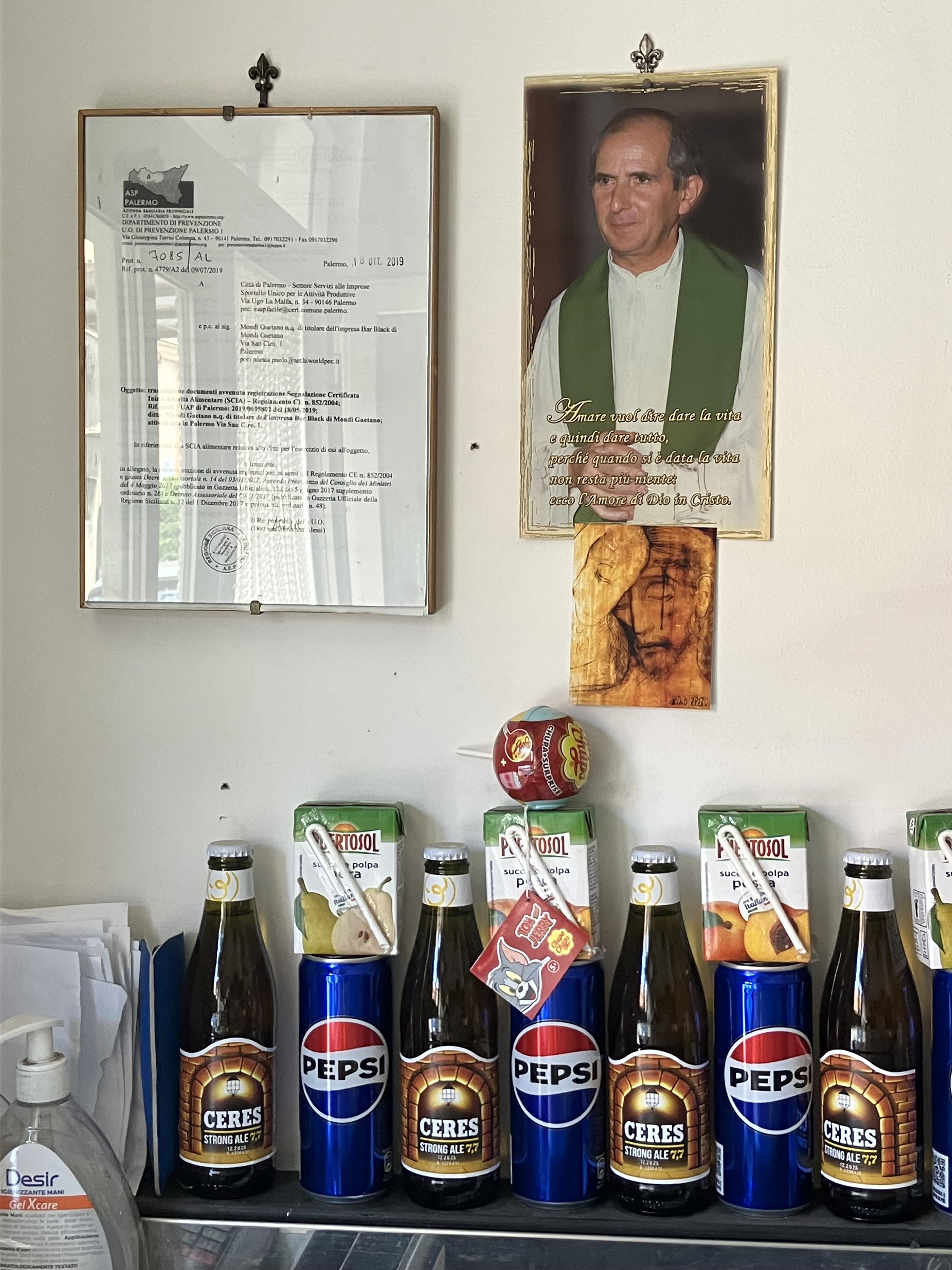foto appese a un muro e bottiglie di bibite