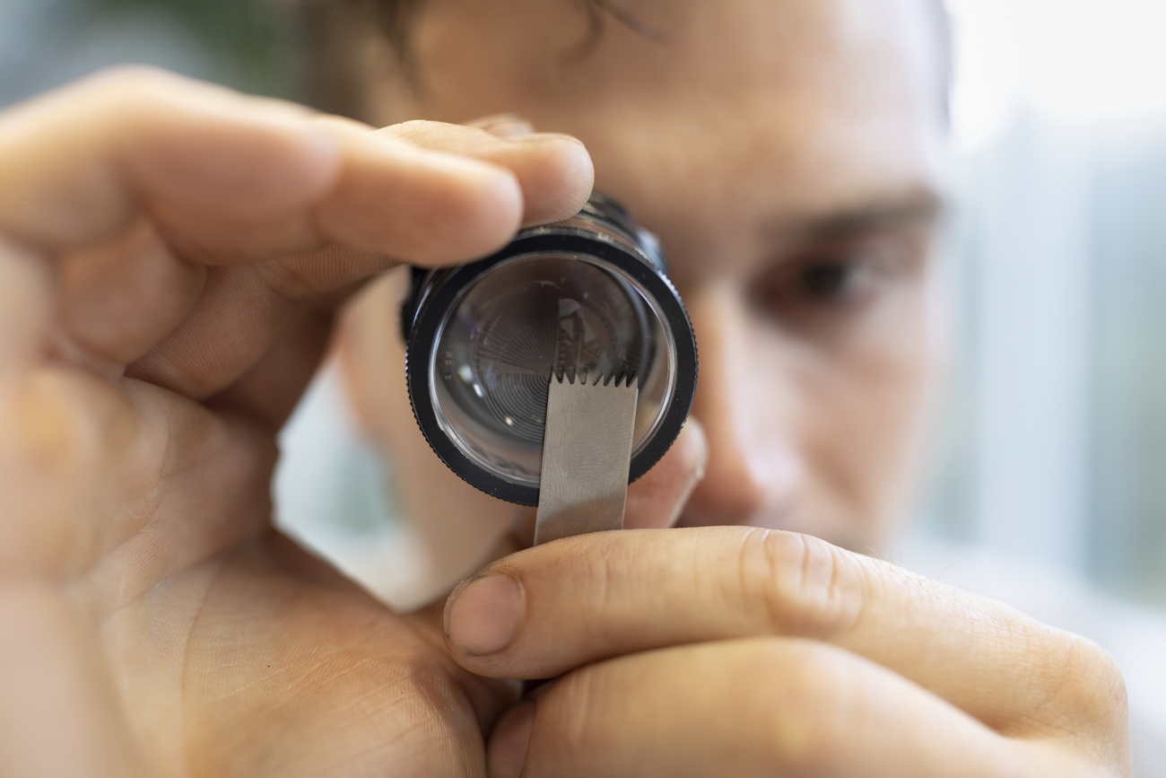 A man checks an oscillating surgical saw blade at one of the leading manufacturers of medical devices for bone surgery, Gomina, in canton Valais.